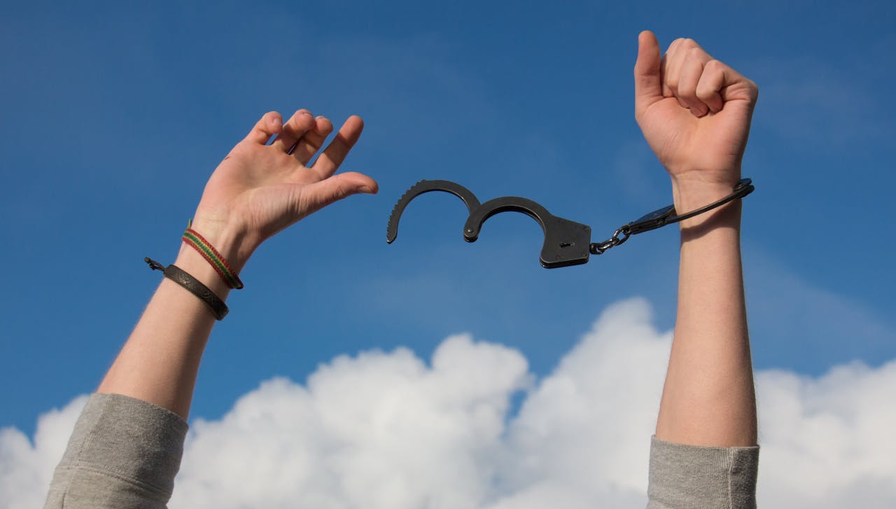 creative-03 Symbolic image of freedom with open handcuffs against a bright blue sky.
