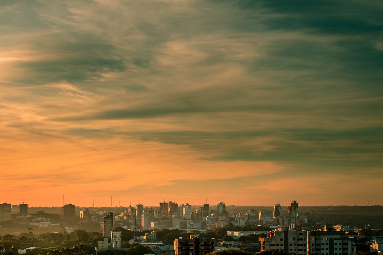 creative-03 Stunning sunset view of Ciudad del Este skyline with dramatic clouds and vibrant colors.